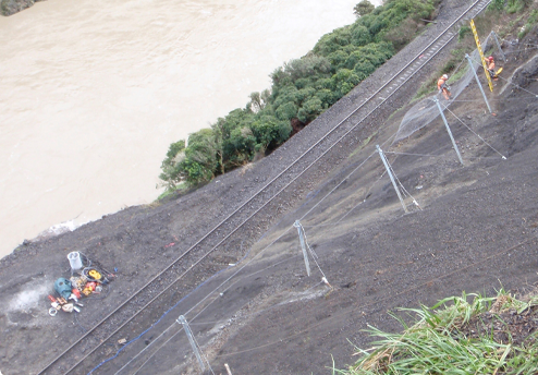 Abseil Access geotechnical team implementing a rockfall barrier above a train line.