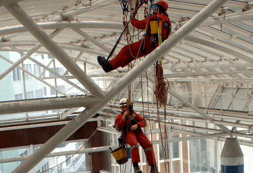 Two of the Abseil Access team performing building maintenance on internal roof structure.